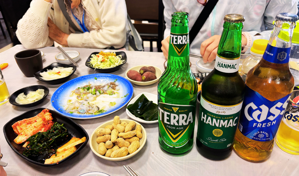 寄港地の釜山にて韓国フードとビールを試す様子